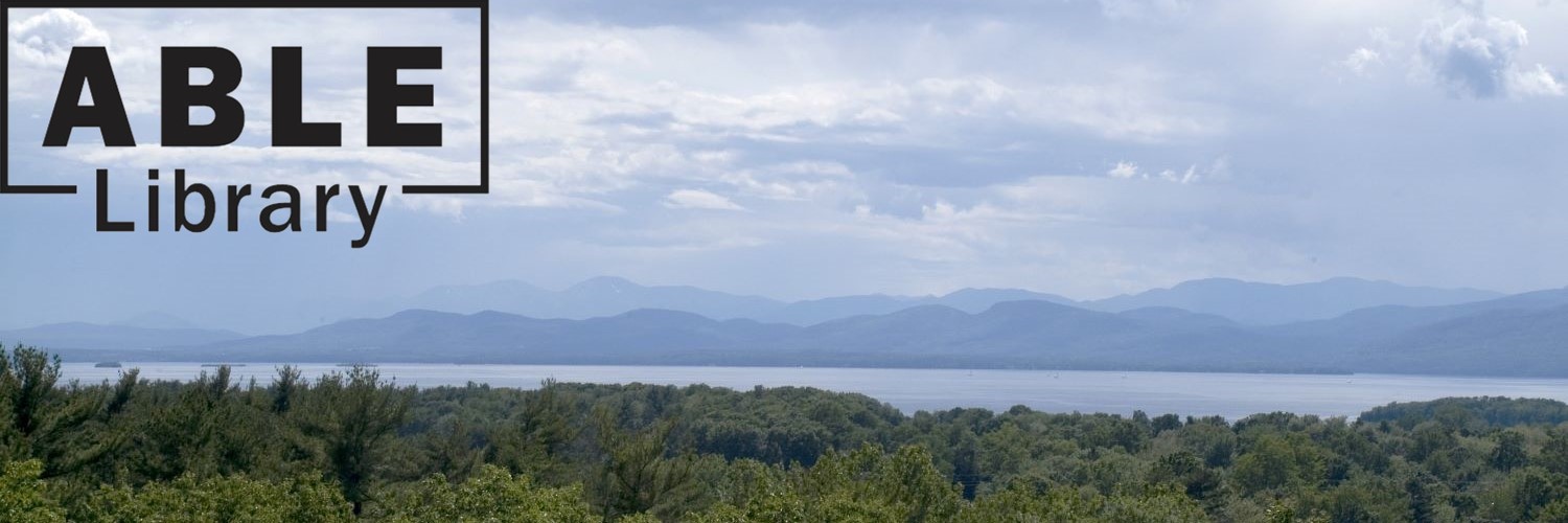 Landscape of green trees in foreground, with Lake Champlain and mountains in the distance with the ABLE Library logo